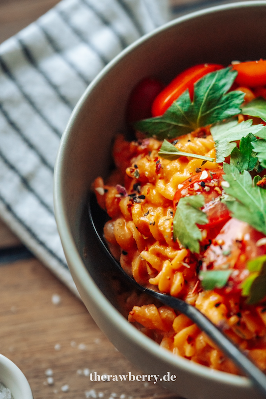 Nudeln in Schüssel mit Paprikasoße mit Tomaten und Koriander