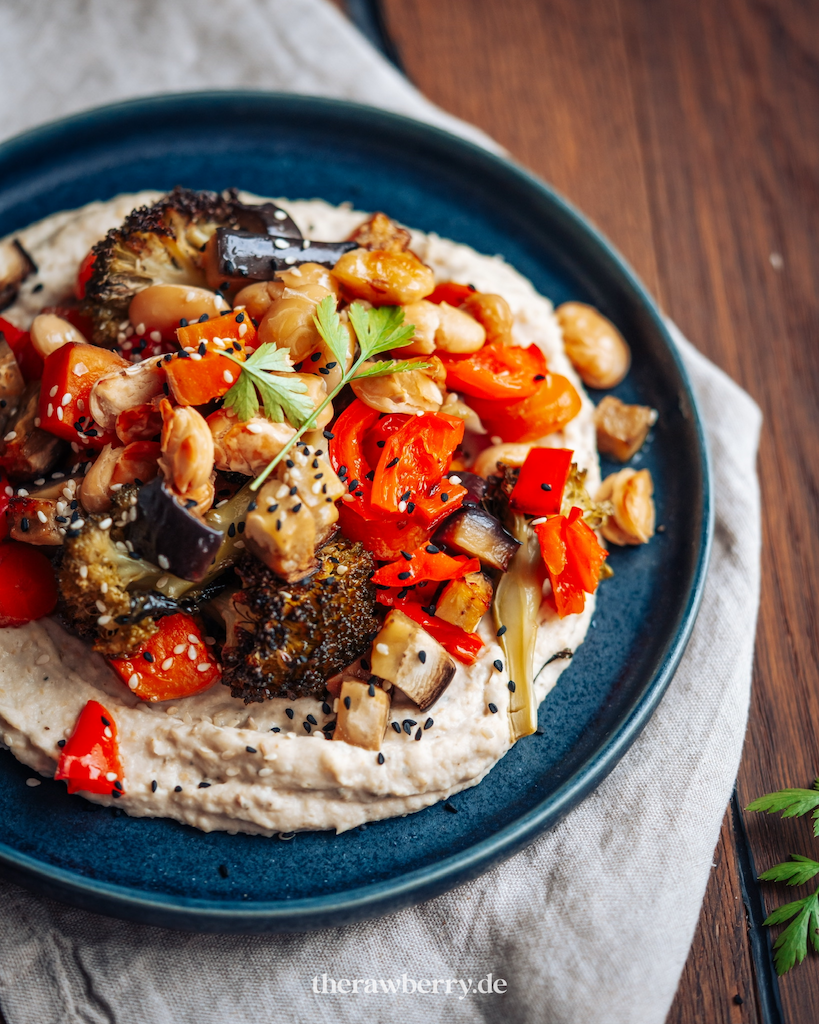 Grillgemüse auf weiße Bohnen Hummus auf dunklem Teller